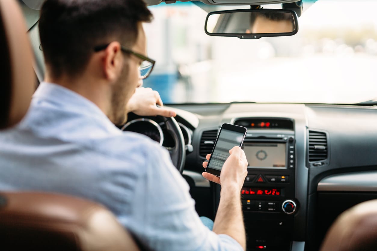 transportation concept - man using phone while driving the car