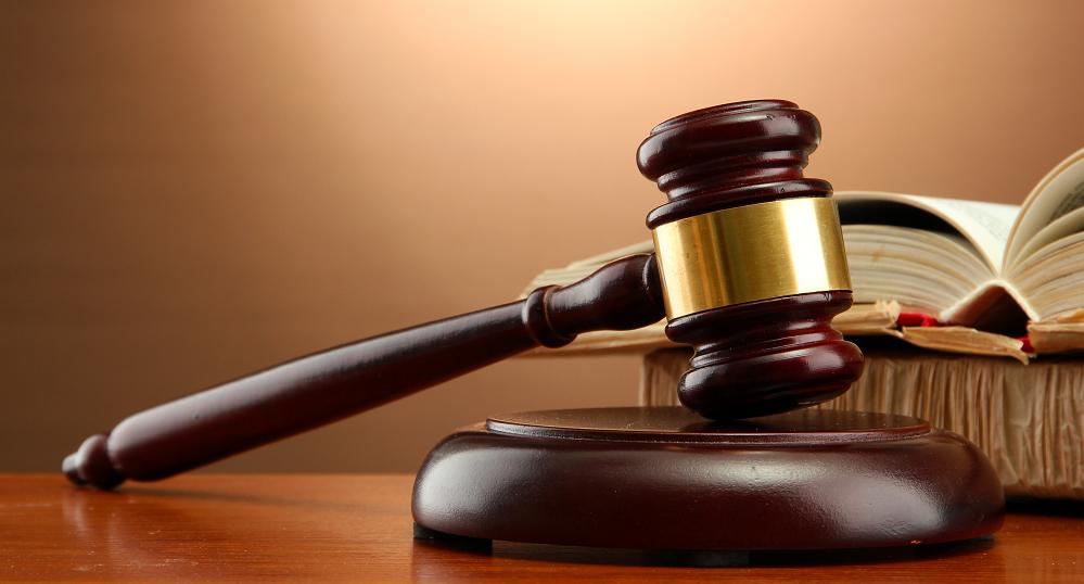 wooden gavel and books on wooden table,on brown background